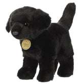 A black Labrador plush toy from Miyoni by Aurora with floppy ears and a glossy black coat.